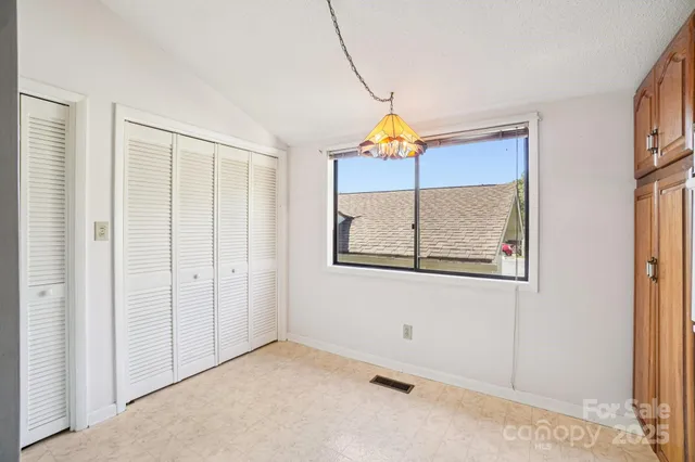 a view of a hallway with wooden floor and a chandelier