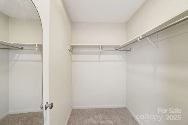 a view of staircase with railing and white walls