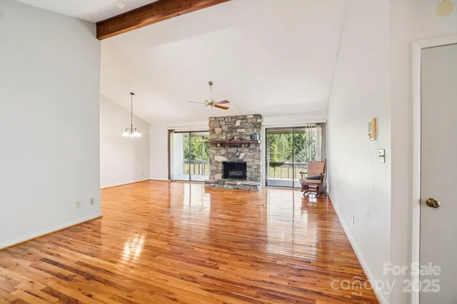 a view of a livingroom with wooden floor and a fireplace