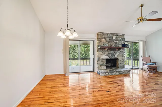 a living room with furniture a fireplace and a floor to ceiling window