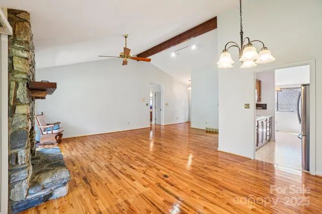 a view of a room with wooden floor and ceiling fan