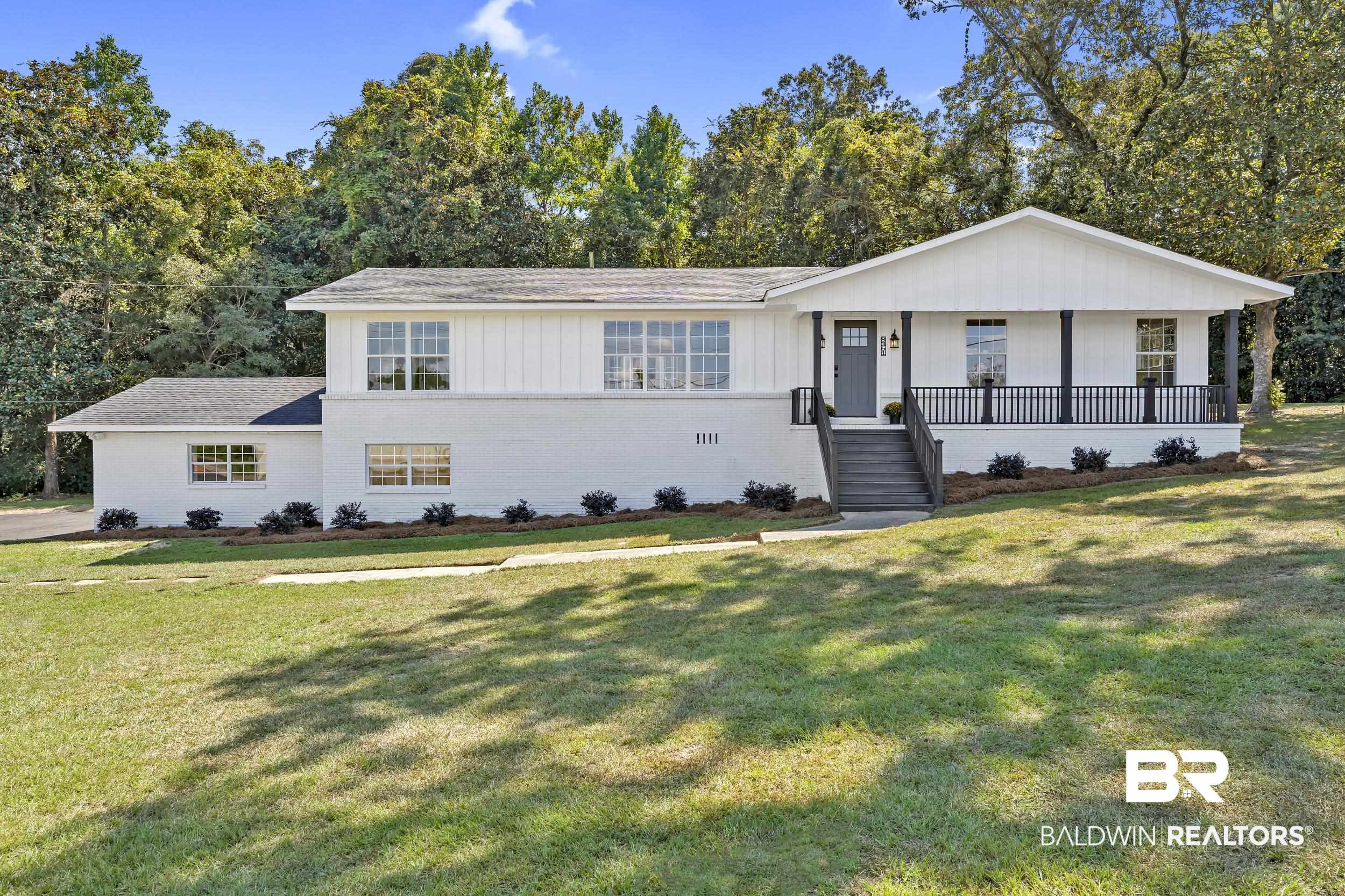 8351 Theodore Dawes Road Theodore, AL 36582 - Photo 2 of 46 View of front of property with brick siding, a porch, a front yard, and board and batten siding
