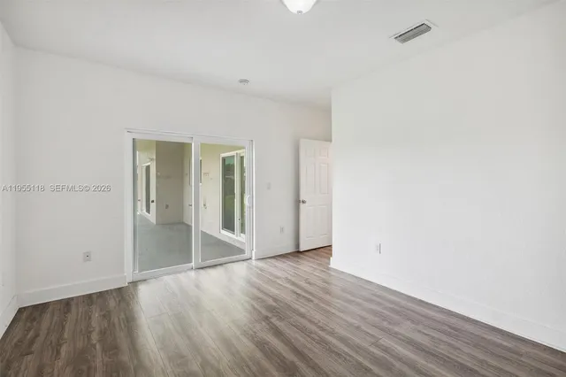 a view of an empty room with wooden floor