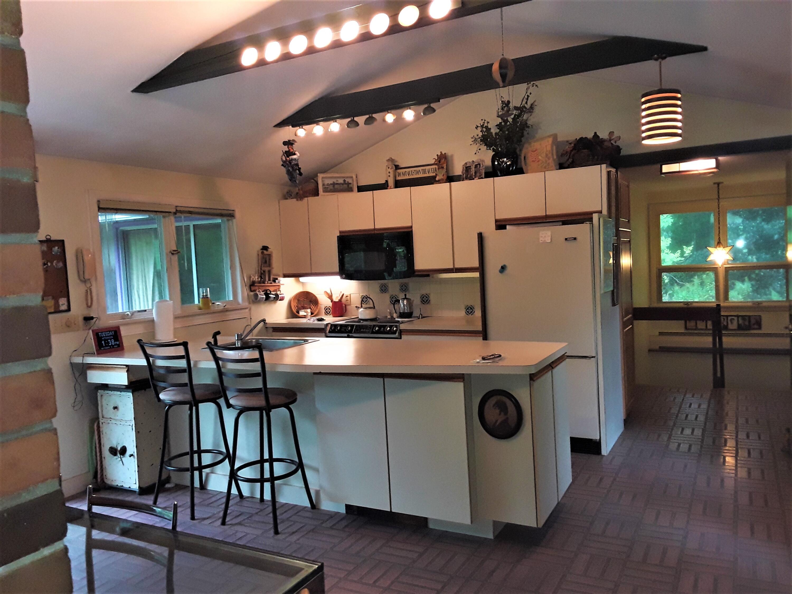 60 Cedar Land Road Orleans, MA 02653 - Photo 9 of 30 a kitchen with kitchen island a stove a table and chairs
