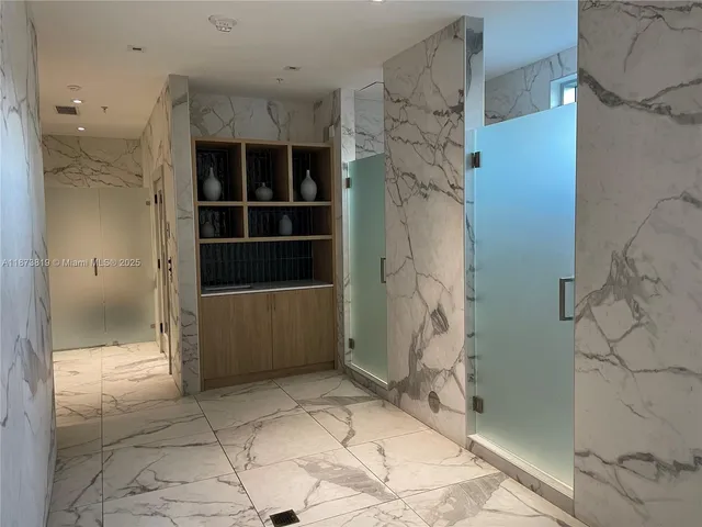 a view of a hallway with toilet and shower