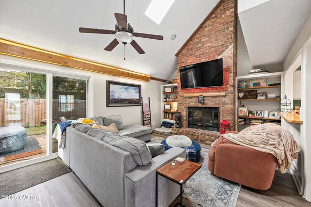 a living room with furniture a fireplace and a flat screen tv