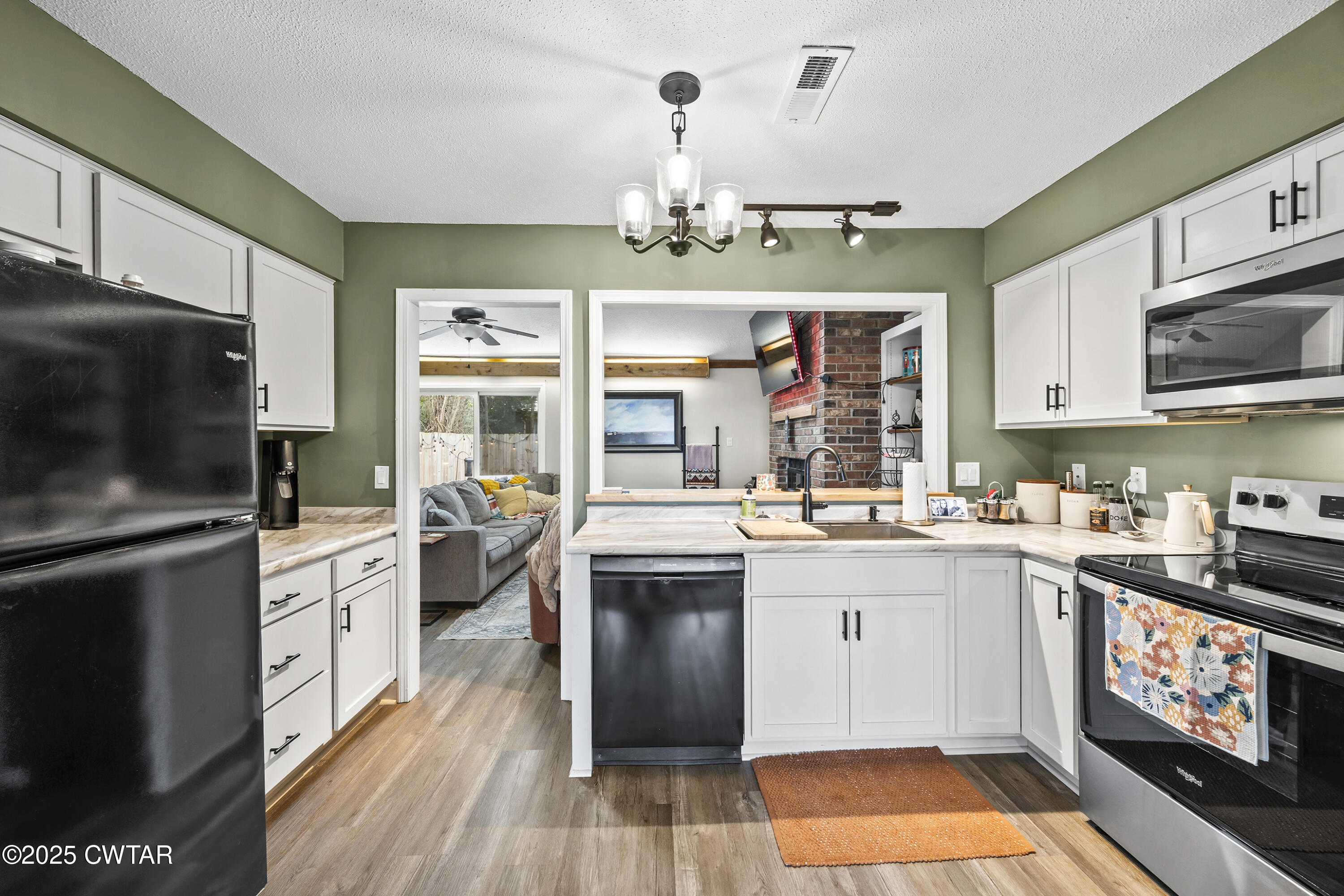 645 Walker Road Jackson, TN 38305 - Photo 6 of 16 a kitchen with stainless steel appliances granite countertop a stove top oven a sink dishwasher and a microwave oven with wooden floor
