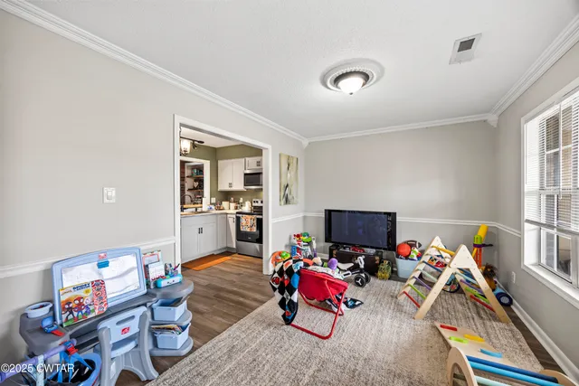 a living room with furniture a flat screen tv and a dining table