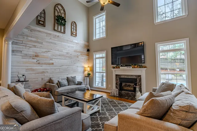 a living room with furniture a flat screen tv and a fireplace