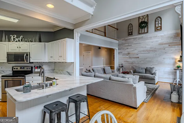 a kitchen with granite countertop a sink stainless steel appliances and cabinets
