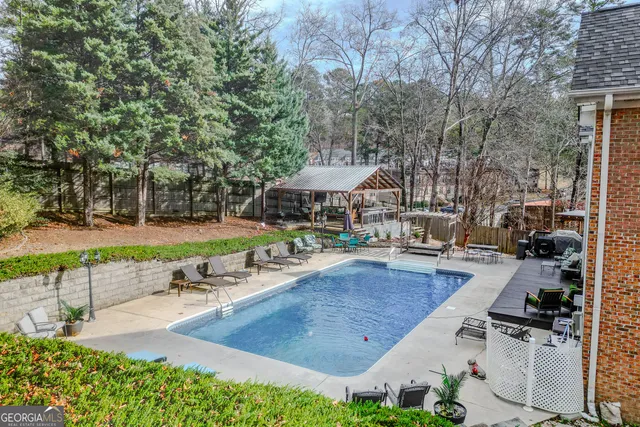a view of a patio with table and chairs potted plants and large tree