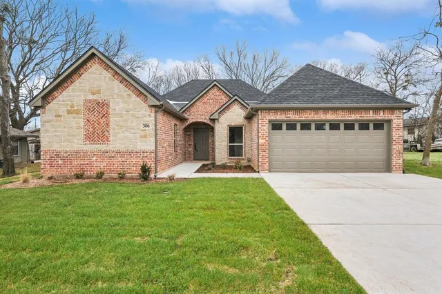 a front view of a house with a yard and garage