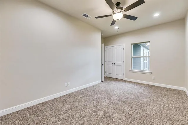 an empty room with fan and windows