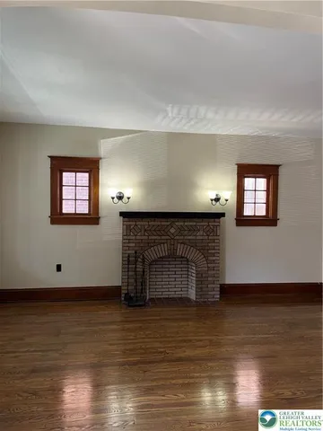 a view of a livingroom with wooden floor and a fireplace