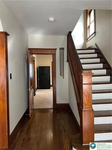 a view of hallway with stairs and wooden floor