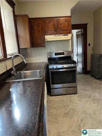 a kitchen with granite countertop a stove and a sink