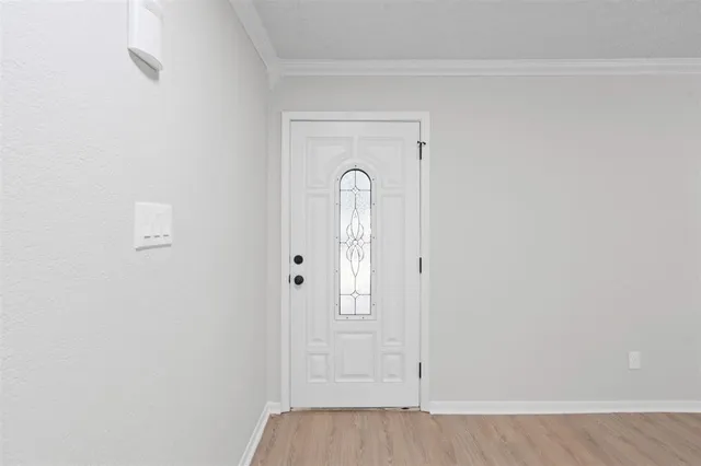 a view of a livingroom with wooden floor and a bathroom