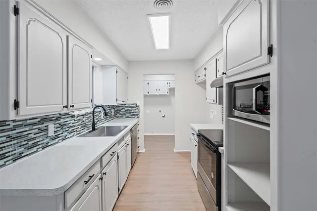 a kitchen with stainless steel appliances a sink stove and refrigerator