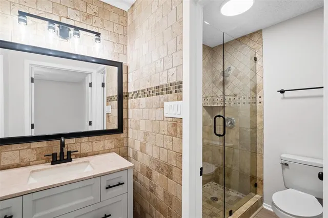 a bathroom with a granite countertop sink toilet and shower