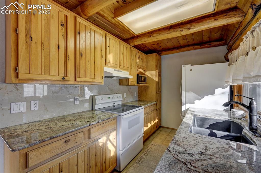 7915 Topeka Avenue Cascade, CO 80809 - Photo 18 of 36 a kitchen with a stove a sink and cabinets