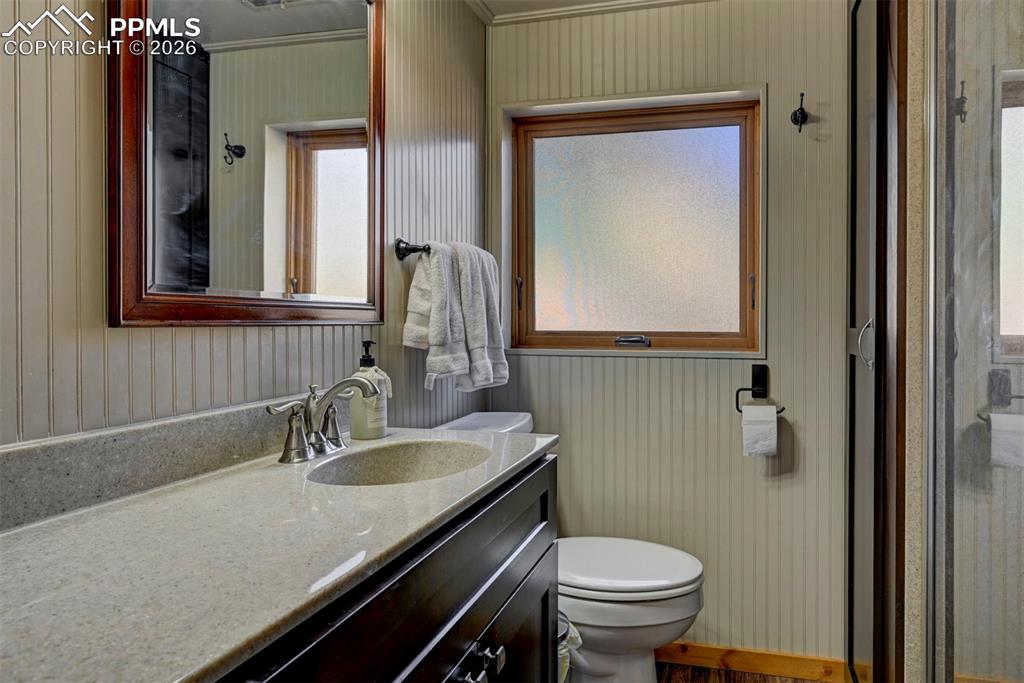 7915 Topeka Avenue Cascade, CO 80809 - Photo 26 of 36 a bathroom with a granite countertop sink a toilet and mirror