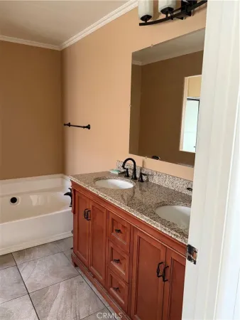 a bathroom with a granite countertop sink a mirror and a bathtub