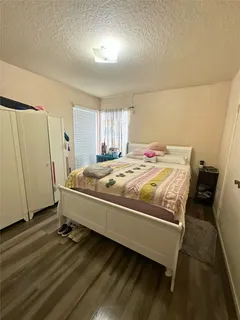 a bedroom with a bed and a flat tv screen on the dresser