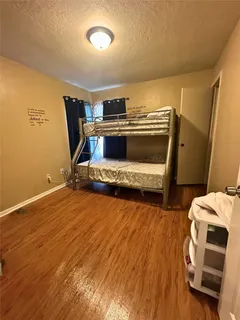 an empty room with wooden floor and mirror