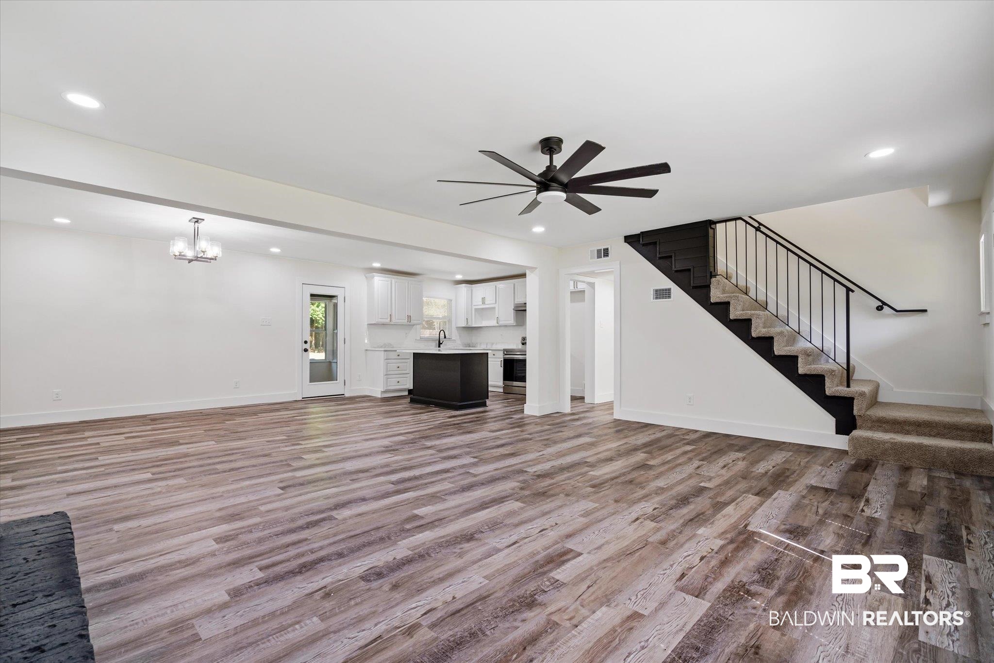 308 Byron Avenue West Mobile, AL 36609 - Photo 3 of 33 Unfurnished living room with ceiling fan with notable chandelier, hardwood / wood-style flooring, and sink