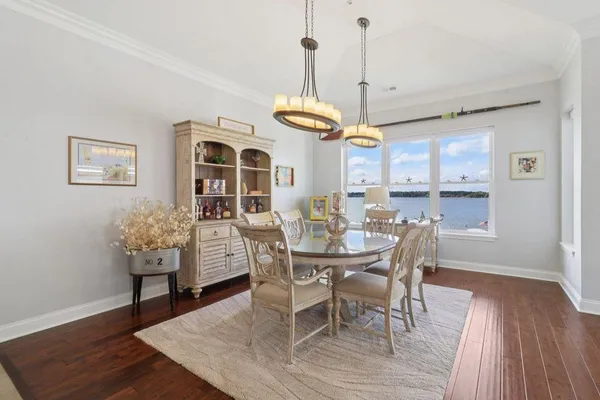 a dining room with furniture a chandelier and wooden floor
