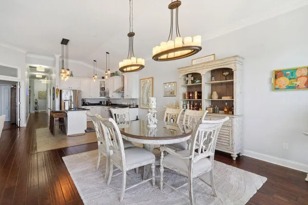 a view of a dining room and livingroom with furniture wooden floor a chandelier