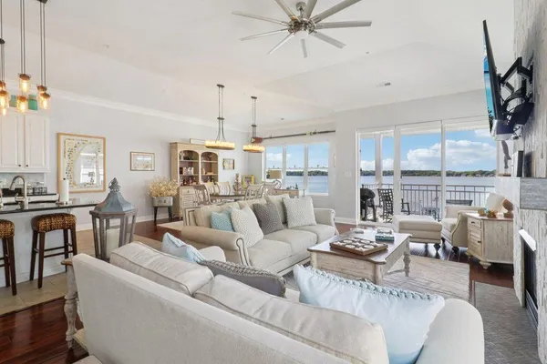 a living room with furniture kitchen view and a large window