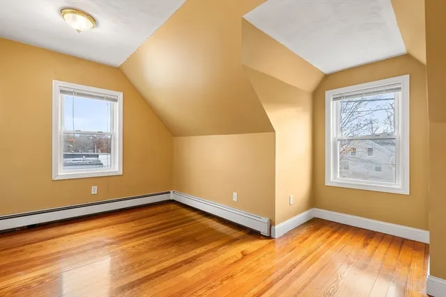 a view of an empty room with window and wooden floor