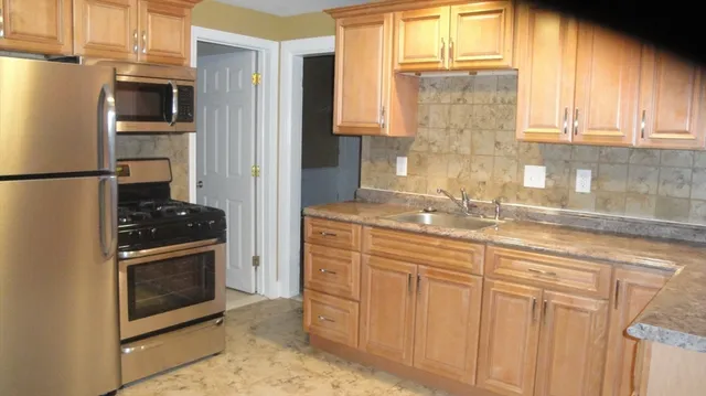 a kitchen with stainless steel appliances granite countertop a refrigerator and a sink