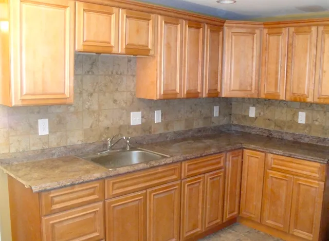 a kitchen with granite countertop cabinets sink and window