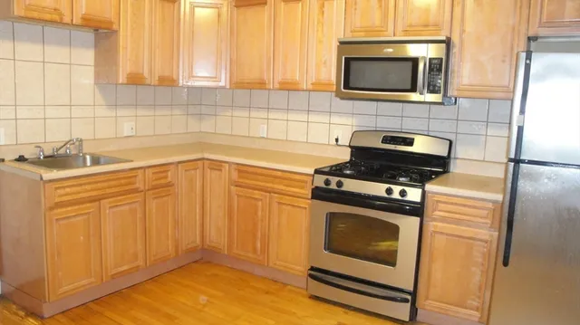 a kitchen with granite countertop cabinets stainless steel appliances and a sink