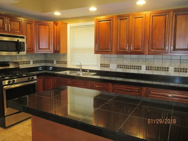 a kitchen with stainless steel appliances a sink a stove cabinets and a counter top space