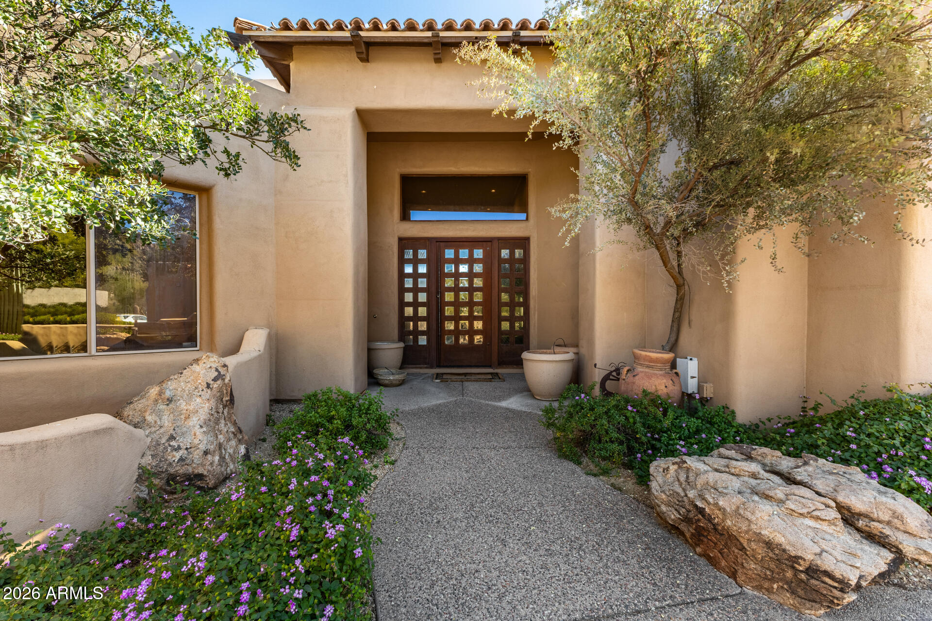 10040 East Happy Valley Road, Unit 2057 Scottsdale, AZ 85255 - Photo 3 of 21 a front view of a house with a yard and fountain in middle
