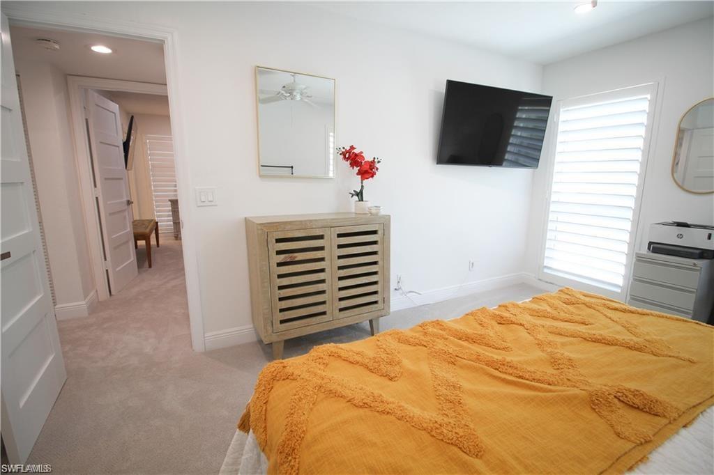 97 Georgetown Boulevard, Unit 97 Naples, FL 34112 - Photo 18 of 25 a bedroom with a bed and a flat screen tv