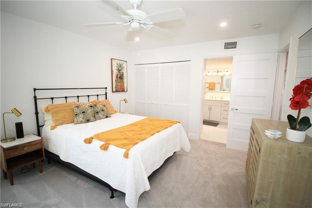 97 Georgetown Boulevard, Unit 97 Naples, FL 34112 - Photo 19 of 25 a bed room with a bed and a potted plant