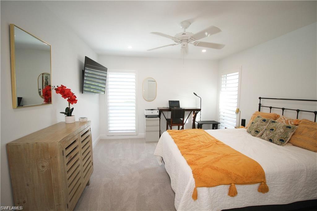 97 Georgetown Boulevard, Unit 97 Naples, FL 34112 - Photo 20 of 25 a bed room with a bed and a chair