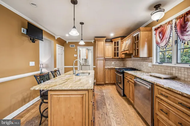 a kitchen with stainless steel appliances granite countertop a sink a stove and a refrigerator