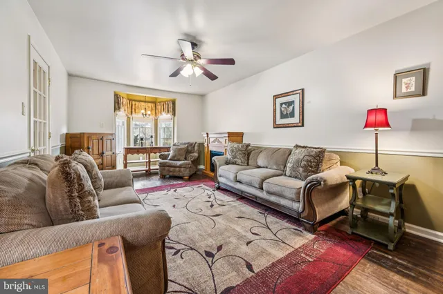 a living room with furniture ceiling fan and a window