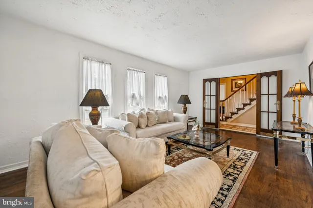 a living room with furniture two window and a flat screen tv