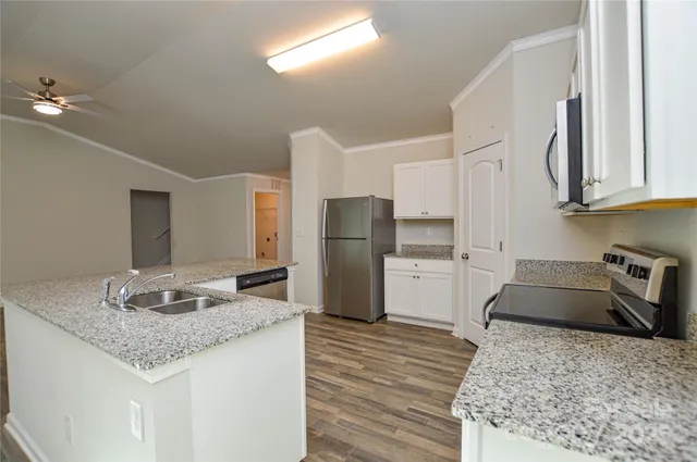 a kitchen with stainless steel appliances granite countertop a sink stove and refrigerator