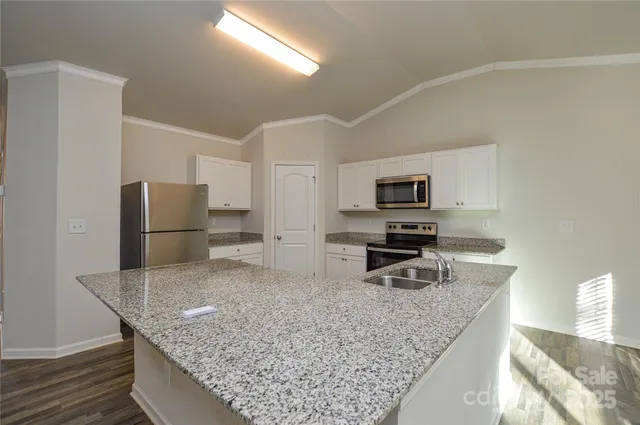 a kitchen with stainless steel appliances granite countertop a sink dishwasher stove and refrigerator