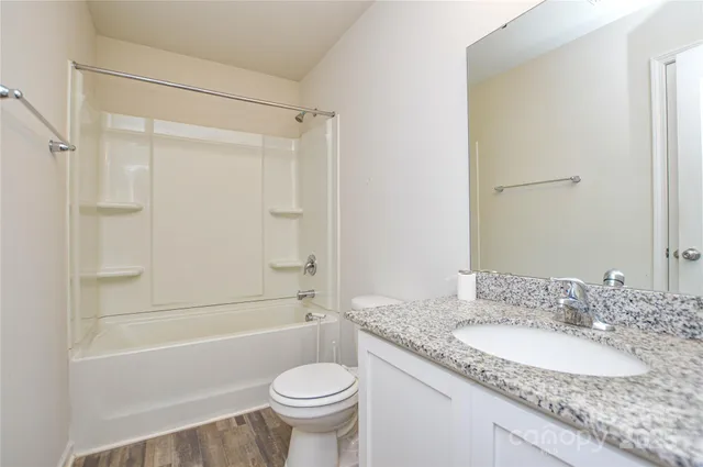 a white toilet sitting next to a bath tub