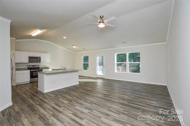 a view of kitchen with refrigerator stove and wooden floor