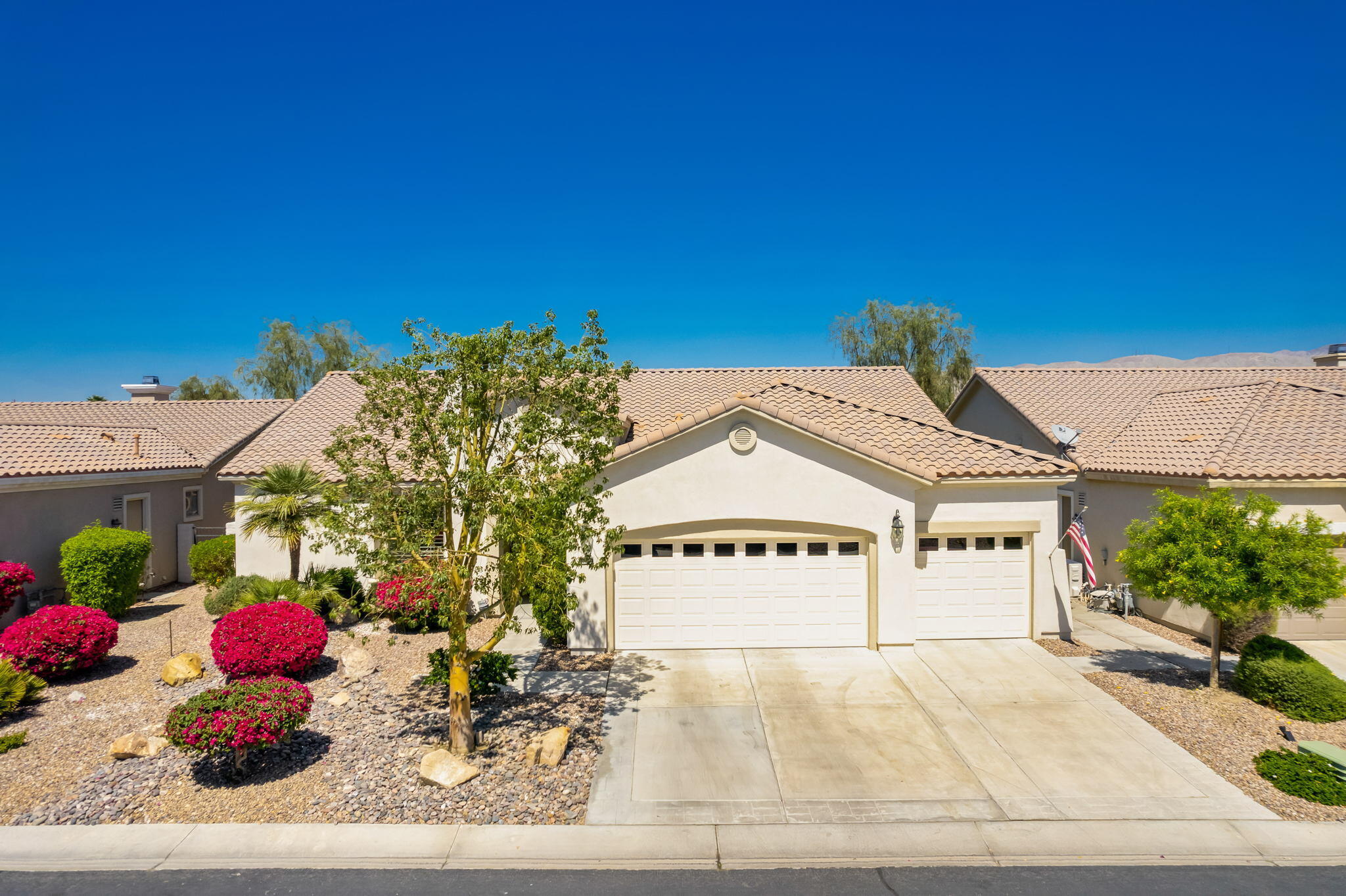 a view of a white house with a yard and potted plants