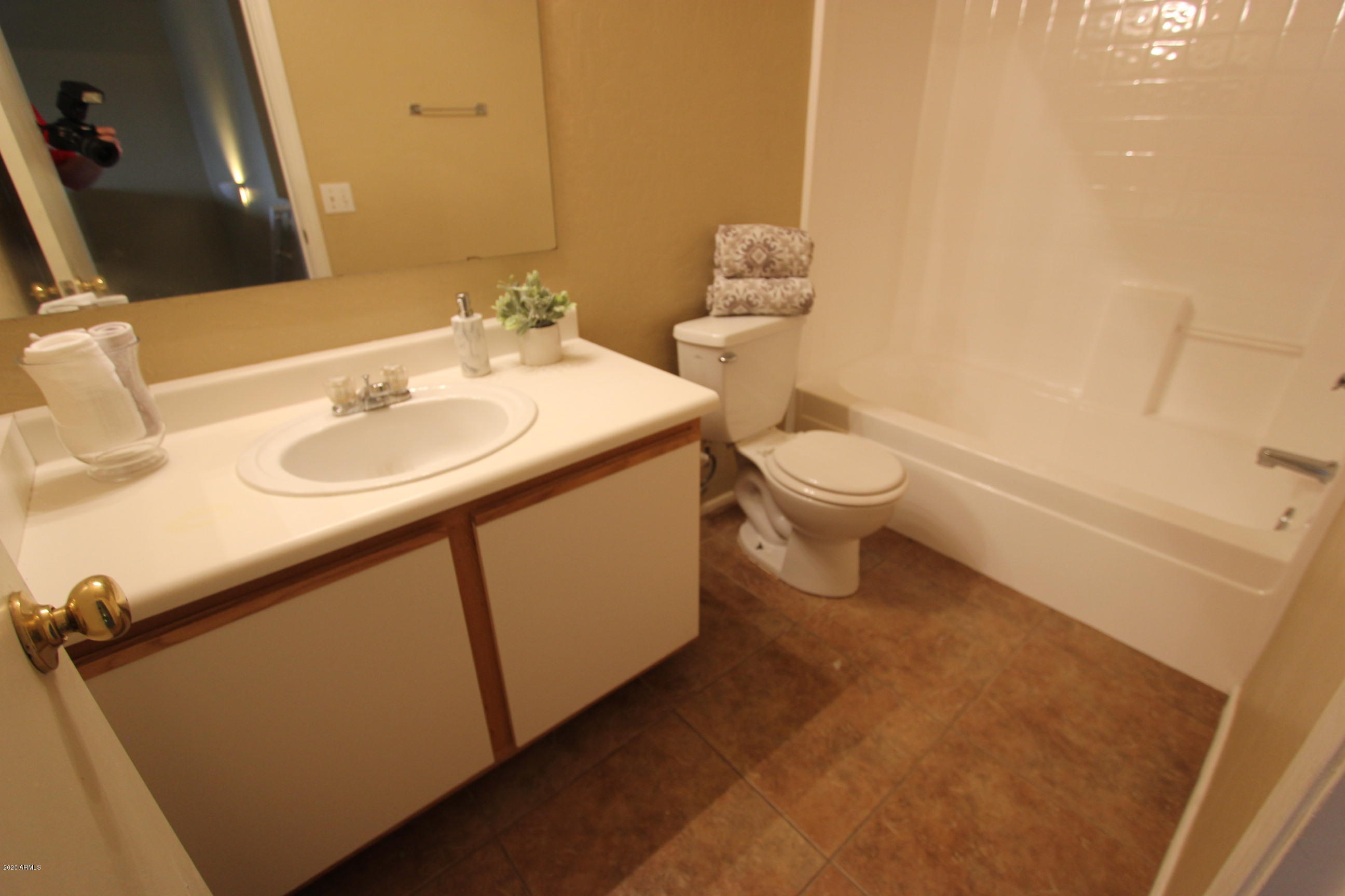 3125 West Fremont Rd. Phoenix, AZ 85041 - Photo 19 of 33 a bathroom with a toilet sink and mirror